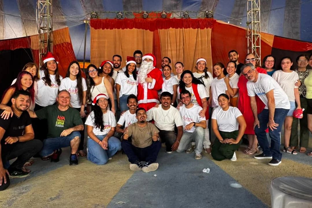 O grupo de voluntários do Natal reunido embaixo da lona, comigo no meio vestido de Papai Noel.