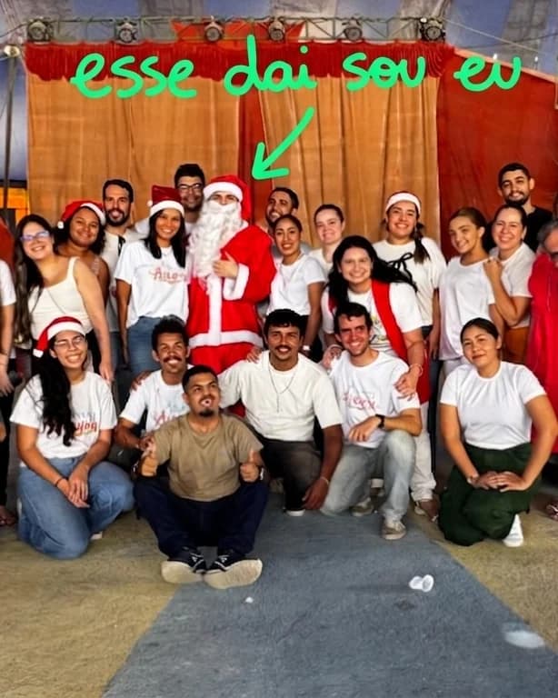 Os participantes do voluntariado de Natal reunidos embaixo da lona, comigo no meio vestido de Papai Noel.